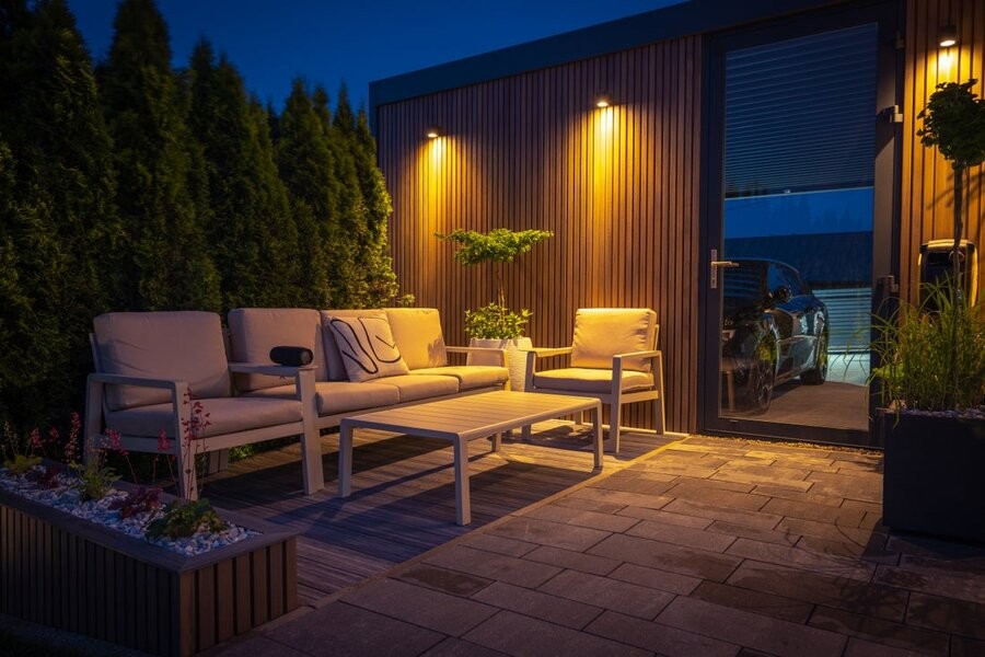 An outdoor patio area featuring seating and outdoor lighting fixtures.