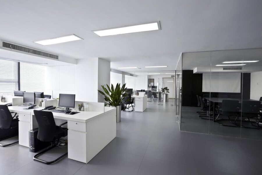 An office space showing desks and individual conference rooms.